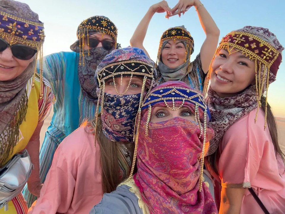 Travelers wearing traditional desert clothing during a thirteen-day Morocco tour from Casablanca