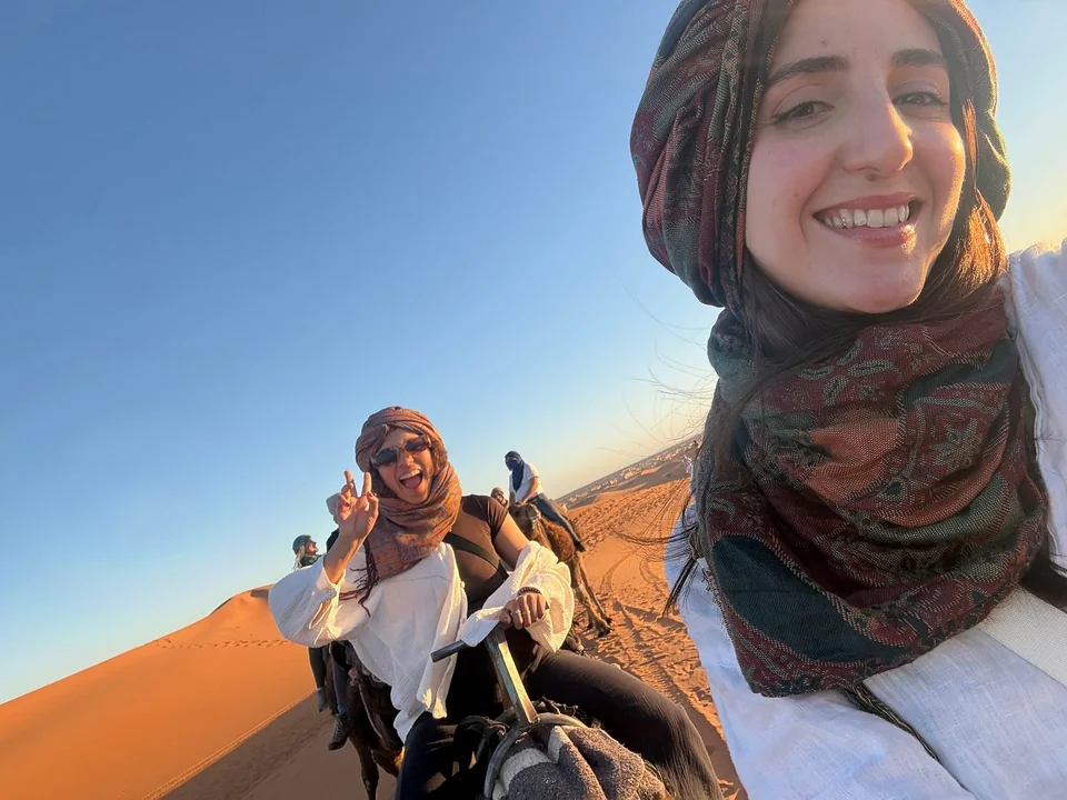 Travelers enjoying a camel ride during a five-day Fes to Marrakech tour