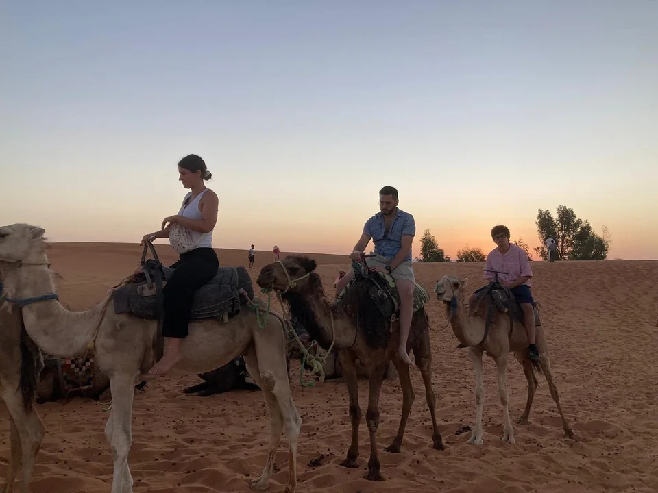 Travelers beginning a sunset camel ride near Merzouga